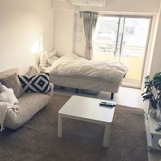 a living room filled with furniture and a white table in front of a sliding glass door