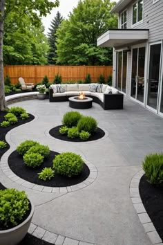 an outdoor patio with black and white landscaping in the middle, surrounded by greenery