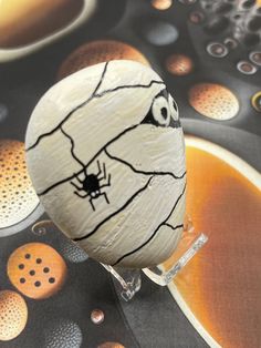 an egg decorated like a spider on top of a table