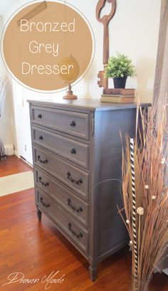 an old dresser has been painted gray and is next to a potted plant