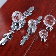 three pieces of jewelry sitting on top of a wooden table