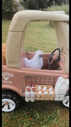 a toy truck with eggs in the back and a stuffed animal sitting in the driver's seat