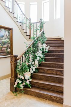 the stairs are decorated with flowers and greenery