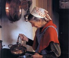 an old woman is cooking in the kitchen