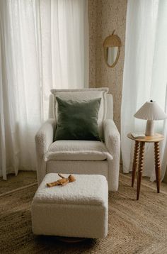 a chair and ottoman in a room with curtains