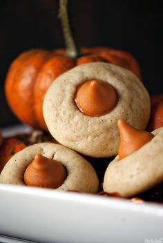 there are some cookies with orange icing on them and pumpkins in the background