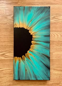 a blue and yellow flower on a wooden surface