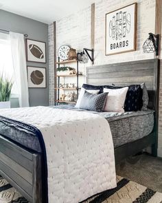 a bedroom with white brick walls and gray bedding, black and white rugs