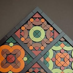 an artistic design made out of different colored circles and squares on a gray surface with black edges