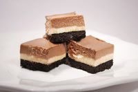 four pieces of cake sitting on top of a white plate