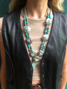 Handmade Turquoise Leather Concho Necklace  - Vibrant turquoise - Double leather strands - Silver tone conchos - Short fringe - A bit uneven since handcrafted see main pic - Plastic turquoise heart beads - Silver tone metal beads - Measures 16" long counting fringe - In good vintage condition showing minor wear and age (a bit uneven since handcrafted see main pic) Concho Necklace, Western Necklace, Western Necklaces, Short Fringe, Turquoise Heart, Turquoise Leather, Heart Beads, Bead Designs, Necklace Handmade