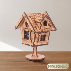 a wooden model of a house sitting on top of a table