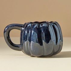 a blue ceramic coffee mug sitting on top of a table