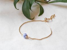 Blue and white porcelain bracelet is so cute. This gold-plated bracelet has a blue and white floral ceramic bead and a box chain slider, which makes it very easy to adjust the length of the bracelet. Timeless piece of jewelry - perfect for both every day wear, as well as special occasions.   You might be interested in matching earrings: https://www.etsy.com/listing/1162478035 See my whole jewelry collection: https://www.etsy.com/shop/Tazelry ♥ Jewelry care ♥ It's important to keep your jewelry dry: Take it off before taking a shower, bath, swimming, or exercising. Always apply your makeup, perfume, and hairspray before putting on your jewelry.  Store your jewelry somewhere dry (not in the bathroom). Porcelain Bead Bracelet, Blue And White Jewelry, Porcelain Bracelet, Bracelet Minimalist, Single Bead, Blue And White Porcelain, White Jewelry, Gold Plated Bracelets, Blue Pearl