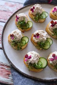 cucumber and cream cheese appetizers on a plate with blue napkins