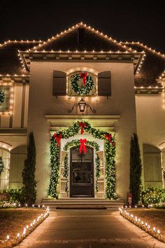 a house with christmas lights and wreaths on the front door