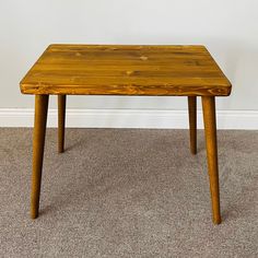 a wooden table sitting on top of a carpeted floor