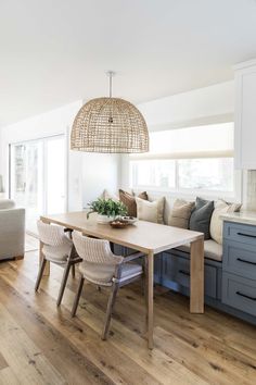 a dining room table with chairs and a bench in the middle, next to a couch