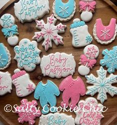 decorated cookies on a wooden platter with snowflakes, mittens and bibs