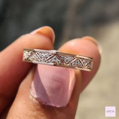 a person holding a wedding ring in their hand with diamonds on the inside of it