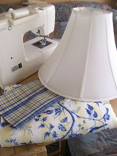 a lamp shade sitting on top of a table next to a sewing machine and folded towels