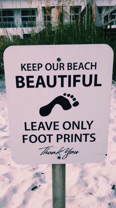 a white sign that says keep our beach beautiful leave only foot prints