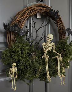 a wreath decorated with fake skeletons and greenery