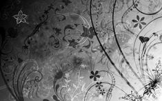 black and white photograph of flowers with swirls on the wall in front of it