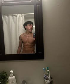 a shirtless man is taking a selfie in the mirror