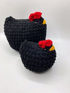 two black crocheted chickens sitting on top of each other