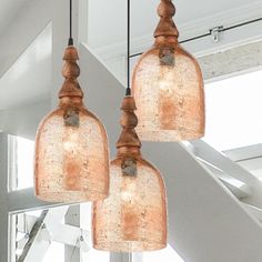 three glass lights hanging from a ceiling in a room with white walls and stairs behind them