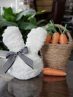 a stuffed bunny next to a basket of carrots