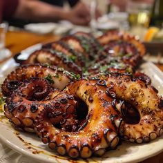 octopus rings on a plate with sauce and herbs