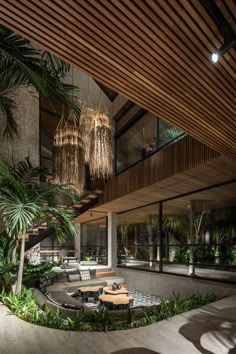 the inside of a modern house with plants and chandeliers hanging from the ceiling