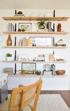 a room with some books on shelves and a chair