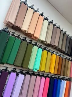 there are many colors of fabric hanging on the wall in this store, and one color is different