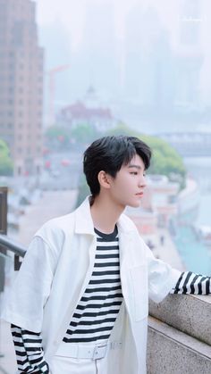 a young man standing on top of a cement wall