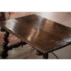 an old wooden table sitting on top of a rug