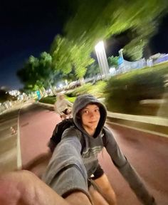 a man riding a skateboard down a street at night