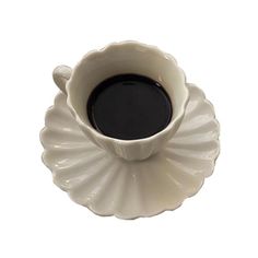 a coffee cup sitting on top of a saucer with black liquid in the middle