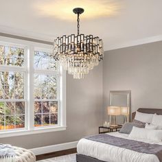 a bedroom with a large bed and chandelier hanging from it's ceiling