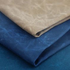 two different colors of fabric on top of each other, one blue and the other beige