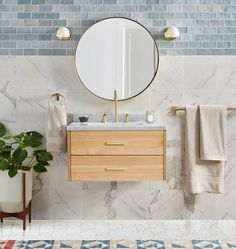 a bathroom with marble walls and blue tiles on the wall, two mirrors above the sink