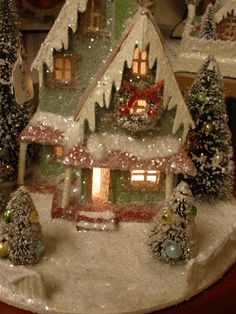 a small christmas village with trees and lights