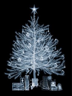 a white christmas tree with lights and presents around it on a black background, surrounded by other items