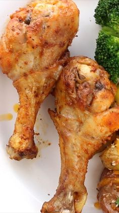 two pieces of chicken on a plate with broccoli and other foodstuffs