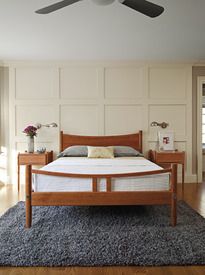 a bed room with a neatly made bed and a ceiling fan