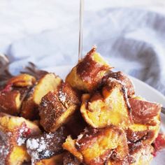 a white plate topped with pastries covered in powdered sugar