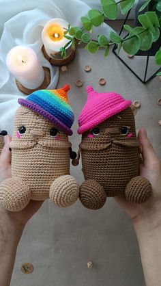 two crocheted dolls are holding each other in front of a table with candles