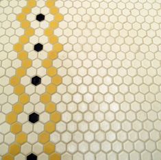 a yellow and black tiled floor with hexagonal tiles on it's sides